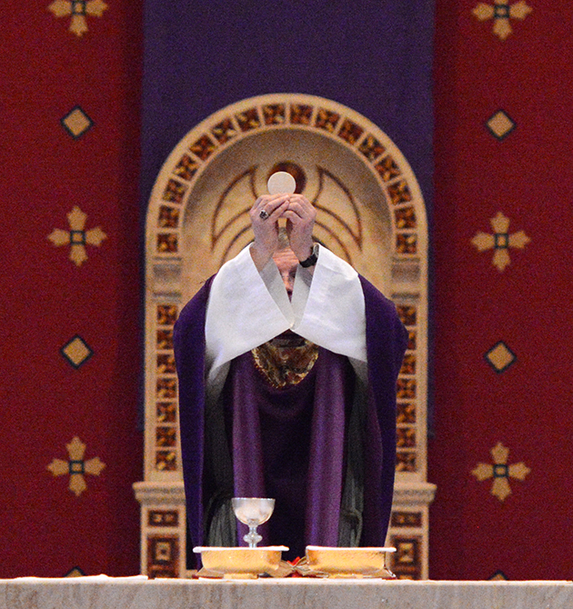 Bishop Joensen holds up the Eucharist