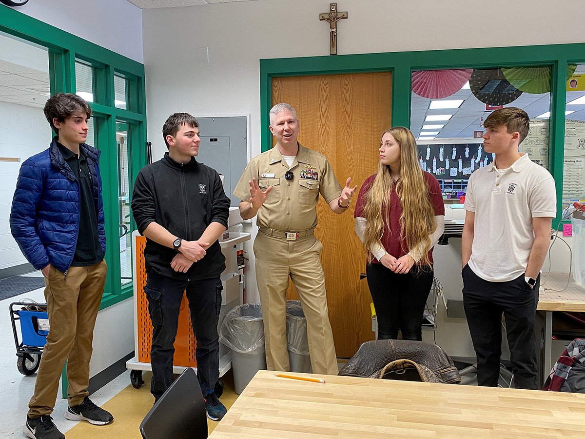 Navy Commander Quintin James talks with students