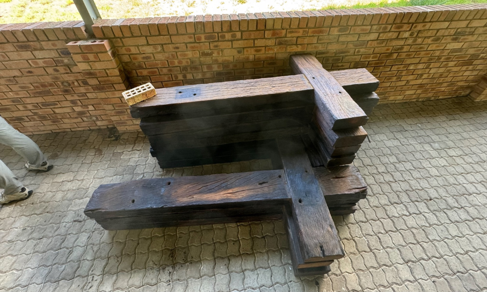 A stack of outdoor crosses made of railroad ties is ready to go up the mountain side and installed in Stations of the Cross. A stack of outdoor wooden crosses waiting to be carried up the mountain