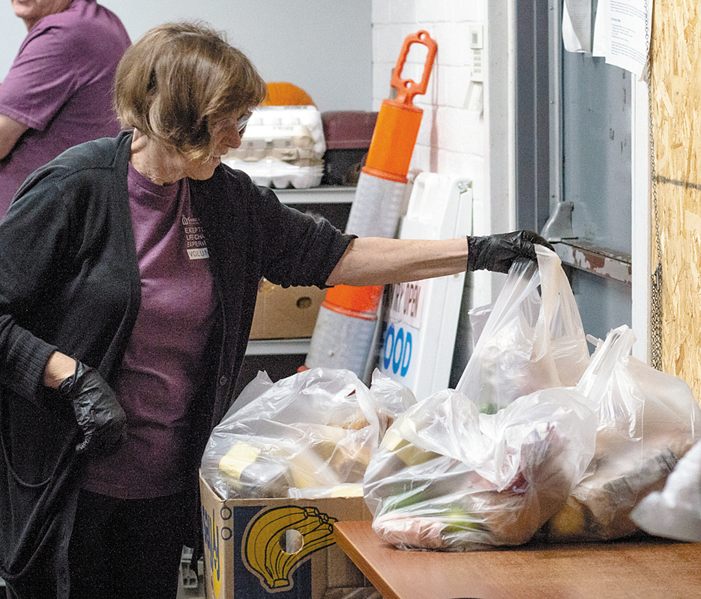 Volunteer packs bags of food for the needy.