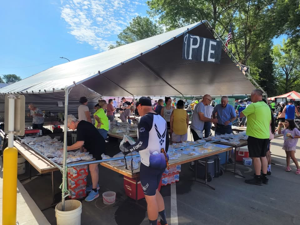 Cyclists pick up pie from the Pie Stand in Exira. 