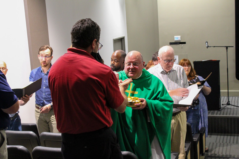 Fr. Dave Fleming gives communion at the Sussman Theater. 