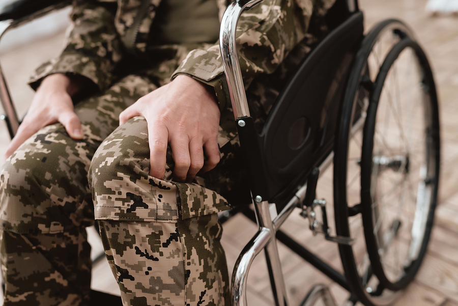 legs of person wearing camouflage pants sitting in wheelchair