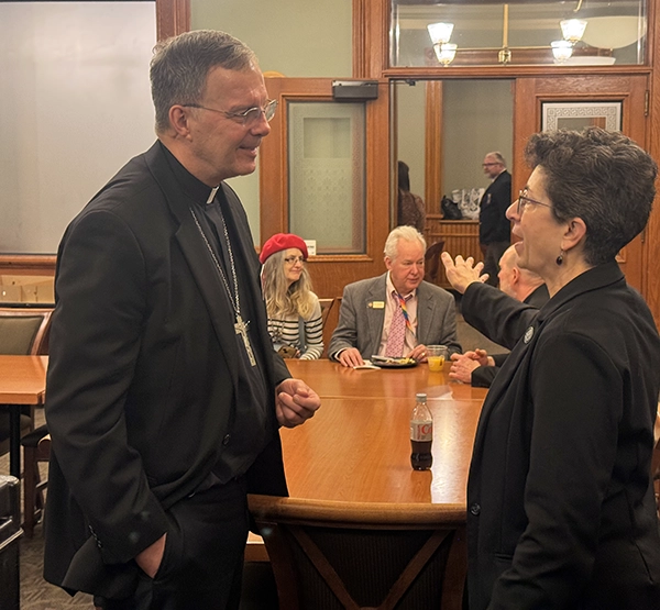 Des Moines Bishop William Joensen talks with a legislat