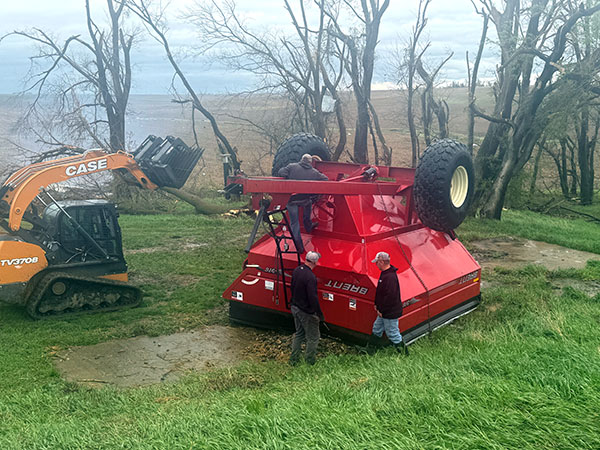 Farmers consider how to turn over a flipped grain bin