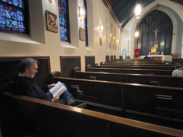 Man prays at adoration at Saint Augustin Church in Des 