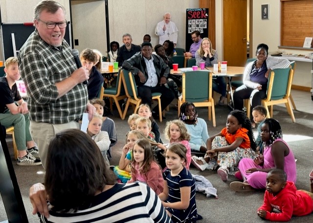 Children and adults alike gather for the first meeting 