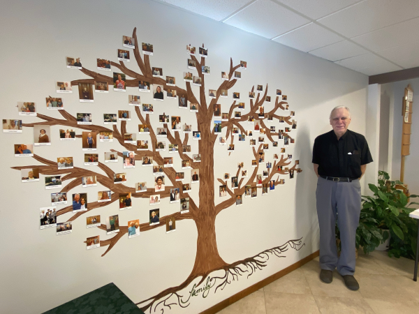 Father Dan Siepker by his parish's family tree