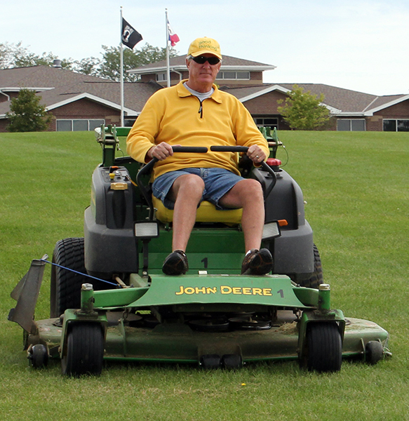 A member of the Knights of Columbus mowing the grass