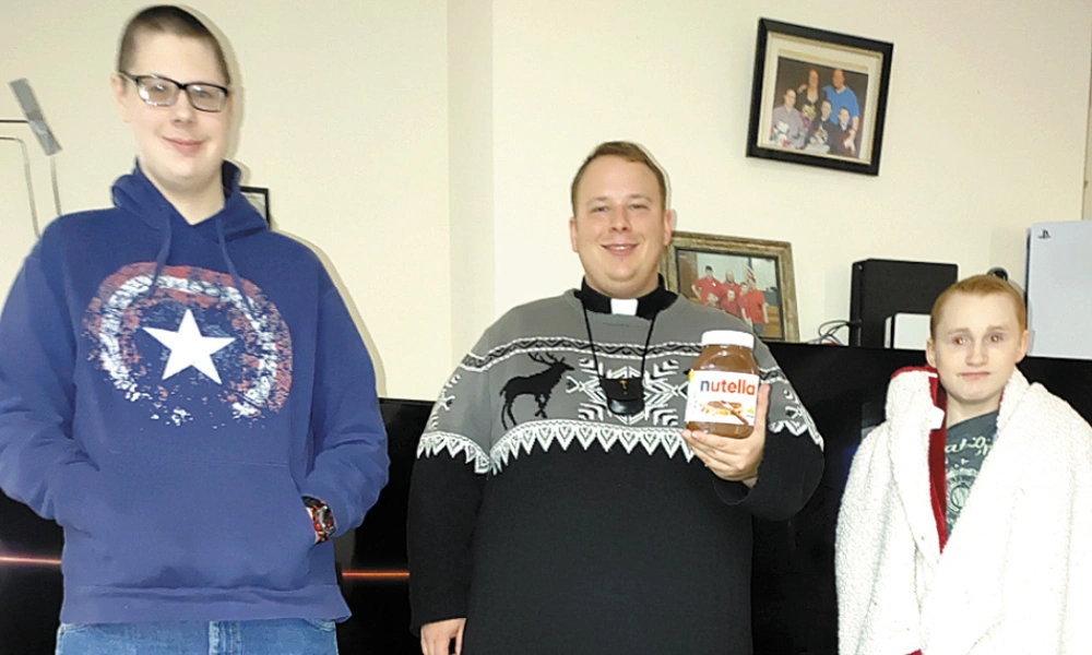 Fr. Nick Stark makes a home visit to the Cross family.