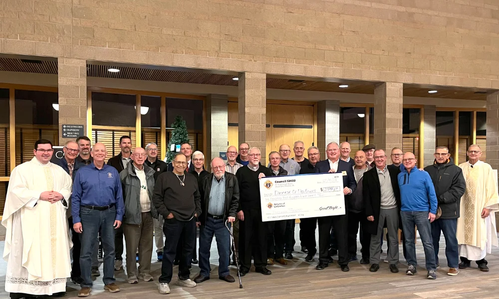 Knights of Columbus present a check to Deacon Jim Houst