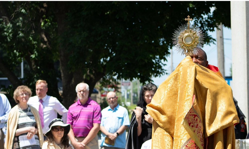 Father Daniel Adjei holds up the Eucharist