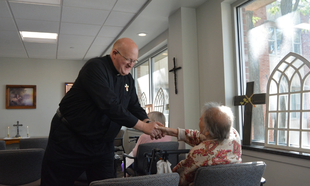 A deacon wearing the traditional black shirt and white 