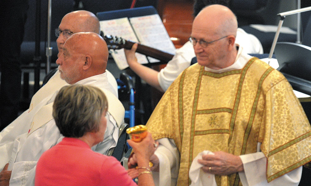 Deacon Bob McClellan, of Corpus Christi Parish in Council Bluffs, shares the cup during Father Luis Mejia's celebration of his 10th anniversary of priestly ordination. Deacon Bob McClellan.