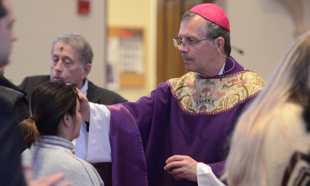 Bishop William Joensen marks a parishioner with ashes