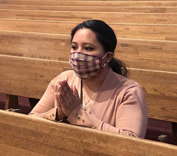 Woman praying with mask on